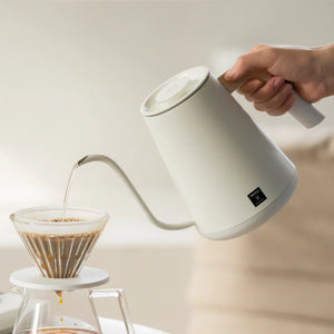 Chaleira elétrica branca com bico estreito e pega em madeira para precisão na preparação, da Timemore, tudo sobre café.