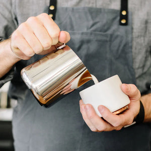 Barista a verter leite de jarro polido em aço inoxidável, parte dos Acessórios de Espresso e Jarro de Leite, tudo sobre café.