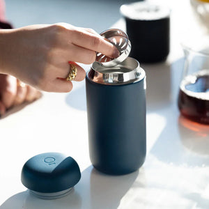 Mão a colocar filtro em chávena de café reutilizável azul mate, parte de Take away e EspressoGear, tudo sobre café.